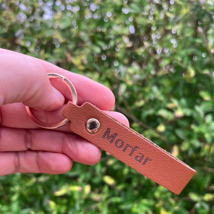 Nyckelring i läder med personlig lasergravyr och metallring.
